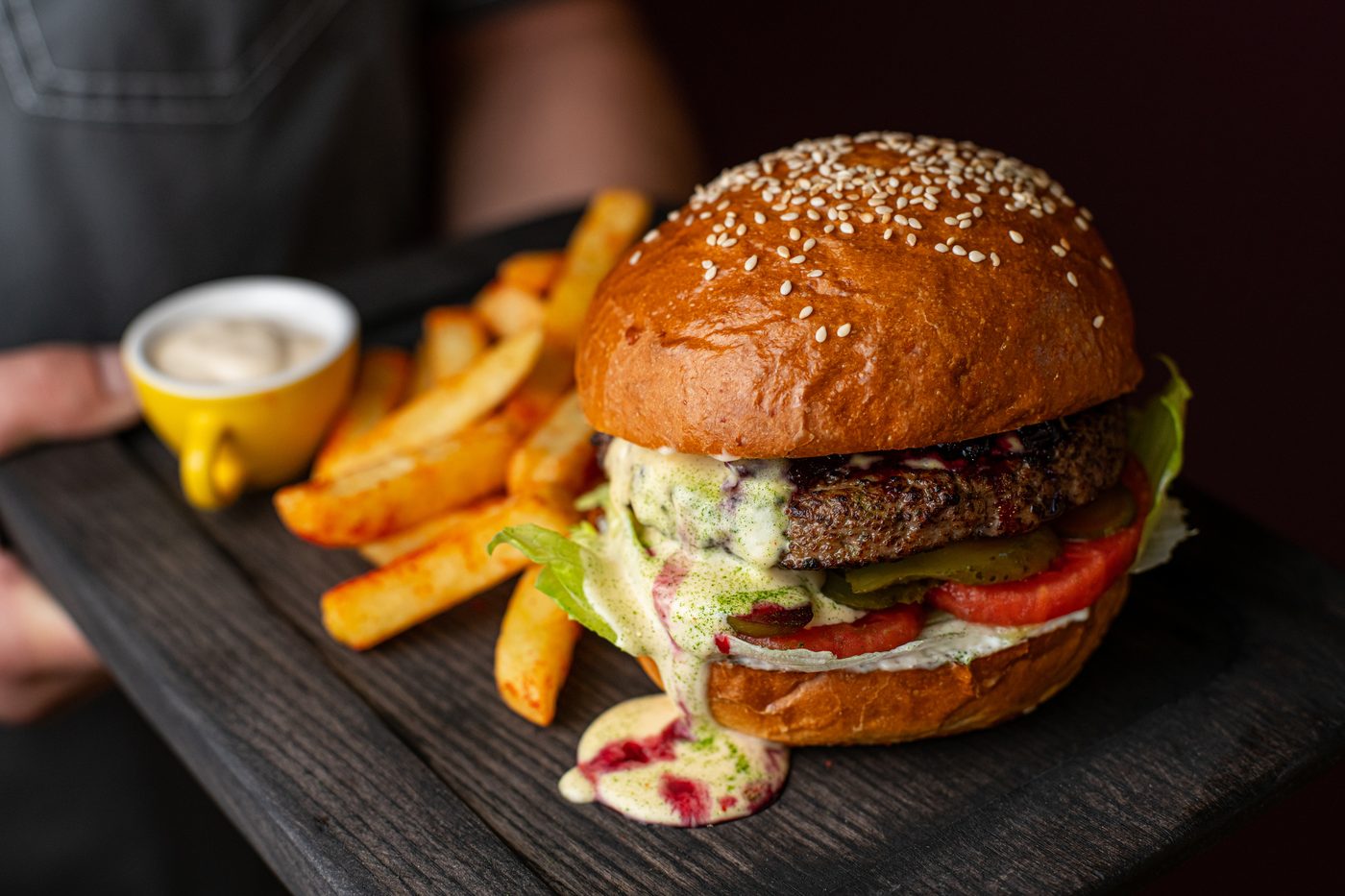Bob's Burger with lettuce, tomato and cheese, served with fries on a slate board