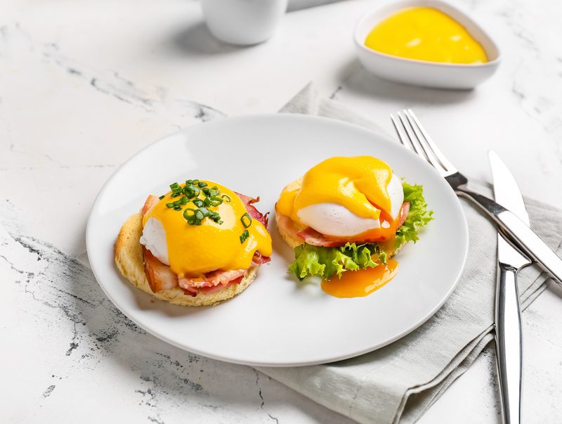 Eggs Benedict with ham and hollandaise on English muffins